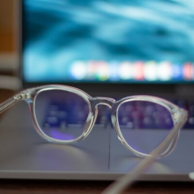 transparent eye glasses sit on a laptop